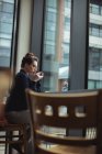 Задумчивая молодая деловая женщина пьет кофе в кафе — стоковое фото