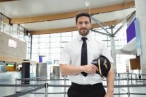 Portrait of pilot standing in airport terminal — Stock Photo