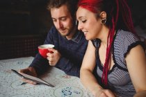 Glückliches Hipster-Paar hält digitales Tablet zu Hause — Stockfoto