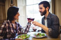 Paar stößt zu Hause auf Gläser Wein an — Stockfoto