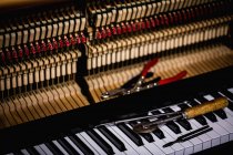 Крупним планом ремонтні інструменти, що зберігаються на старій клавіатурі піаніно в майстерні — стокове фото