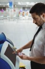 Путешественник с помощью автомата самообслуживания в аэропорту — стоковое фото
