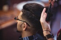 Man getting his hair trimmed in barber shop — Stock Photo