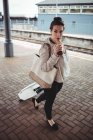 Tutta la lunghezza della giovane donna che trasporta valigia alla piattaforma della stazione ferroviaria — Foto stock