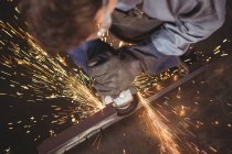 Schweißer schneidet Metall mit Elektrowerkzeug in Werkstatt — Stockfoto