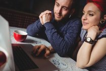 Young hipster couple using laptop at home — Stock Photo