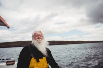Nachdenklicher Fischer, der vom Fischerboot auf das Meer blickt — Stockfoto