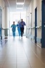Doctor and nurses running in passageway of hospital during emergency — Stock Photo