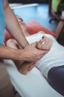 Fisioterapeuta massageando a mão de paciente do sexo feminino na clínica — Fotografia de Stock