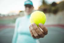 Крупный план теннисного мяча в руке теннисистки — стоковое фото