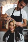 Männlicher Friseur stylt Kunden Haare im Salon — Stockfoto