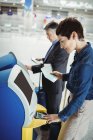 Les hommes d'affaires qui utilisent des enregistreurs libre-service à l'aéroport — Photo de stock