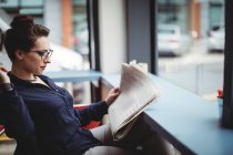 Бізнес-леді читає газету в кафе — стокове фото