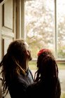 Seitenansicht eines Ehepaares, das zu Hause am Fenster steht — Stockfoto
