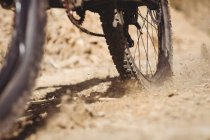 Cropped image of bicycle wheel on field — Stock Photo