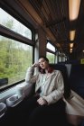 Jolie femme dormant par la fenêtre dans le train — Photo de stock