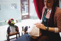 Barbiere applicare un asciugamano caldo su un volto cliente in negozio di barbiere — Foto stock