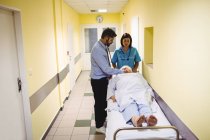 Arzt untersucht Seniorin auf Krankenhausflur — Stockfoto
