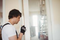 Carpentiere misurazione telaio della porta a casa — Foto stock