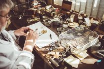 Горолог ремонтирует часы в мастерской — стоковое фото