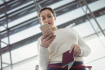 Junge Passagierin benutzt Handy im Flughafen-Terminal — Stockfoto