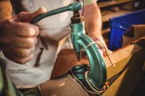 Mid section of shoemaker using sewing machine in workshop — Stock Photo