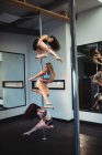 Танцоры на шесте практикуют танец на шесте в фитнес-студии — стоковое фото