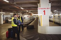 Bodenpersonal am Flughafen beim Entladen des Gepäcks aus dem Gepäckband im Flughafenterminal — Stockfoto