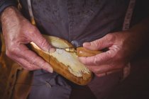 Hands of shoemaker stitching shoe sole with needle in workshop — Stock Photo