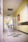 Vista interior do corredor no hospital com paciente do sexo feminino em segundo plano — Fotografia de Stock