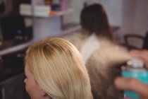 Friseur stylt Kunden Haare mit Spray im Salon — Stockfoto