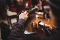 Man getting his hair trimmed with trimmer in barber shop — Stock Photo