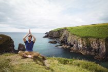 Uomo che esegue yoga sulla scogliera — Foto stock