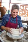Happy male potter making pot in workshop — Stock Photo