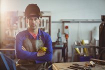 Portrait of male welder standing with arms crossed in workshop — Stock Photo