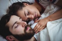 Paar schläft zusammen auf Bett im Schlafzimmer — Stockfoto