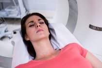 Patient lying on mri machine in scanning room at hospital — Stock Photo