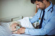 Лікар кладе кисневу маску на пацієнта в лікарню — стокове фото