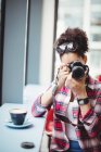 Жінка використовує камеру, стоячи в ресторані — стокове фото