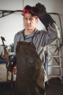 Portrait de soudeur debout avec machine à souder en atelier — Photo de stock