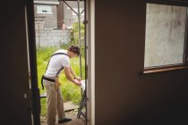 Charpentier mesurant cadre de porte à l'extérieur maison — Photo de stock