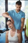 Фізіотерапевт розтягує шию пацієнта жінки в клініці — стокове фото