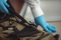 Oficial de segurança do aeroporto usando um detector de metais para verificar um saco no aeroporto — Fotografia de Stock