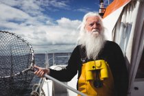Pescatore che tiene la rete da pesca in barca — Foto stock