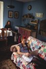 Высокоугольный вид женщины, использующей ноутбук, в то время как мужчина сидит дома — стоковое фото