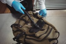 Flughafensicherheitsbeamter kontrolliert mit einem Metalldetektor eine Tasche am Flughafen — Stockfoto