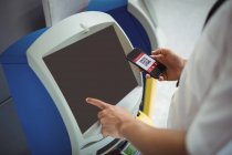 Viajante usando máquina de check-in de auto-atendimento no aeroporto — Fotografia de Stock