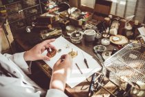 Mid section of horologist repairing a watch in the workshop — Stock Photo