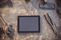 Top view of Digital tablet and tools on table in workshop — Stock Photo