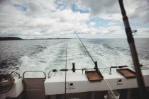 Fishing rods on fishing boat at sea — Stock Photo